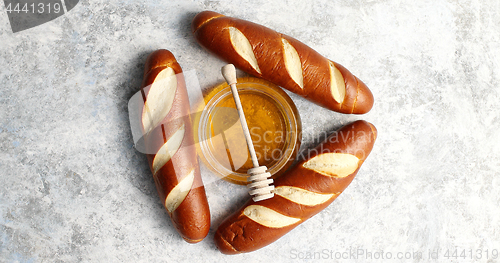 Image of Three loafs with bowl of honey in middle