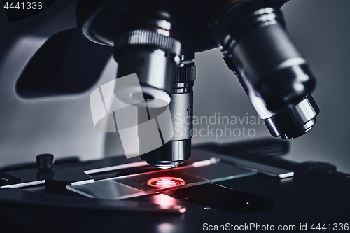 Image of Modern microscope with metal lens at laboratory.