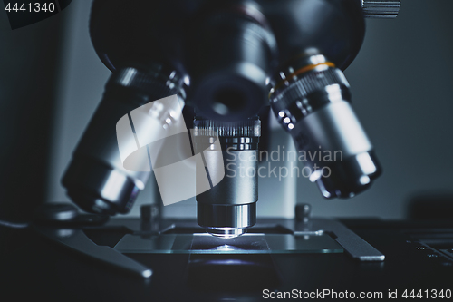 Image of Modern microscope with metal lens at laboratory.