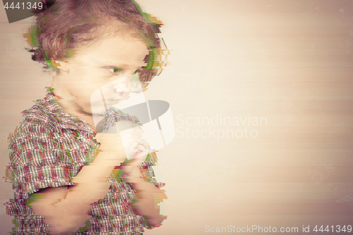 Image of portrait the one sad little boy standing near a  wall