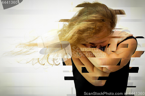 Image of one sad man sitting near a  wall and covers his face