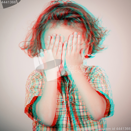 Image of Portrait of sad little boy standing near wall