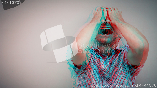 Image of one sad man standing near a  wall and covers his face