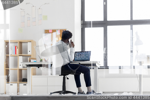 Image of businessman calling on smartphone at office