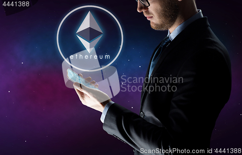 Image of businessman with smartphone and ethereum hologram