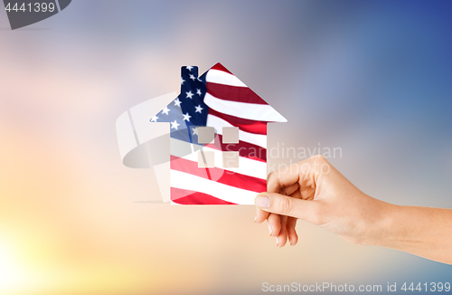 Image of hand holding paper house in colors of american flag