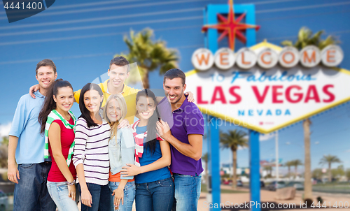 Image of happy friends over welcome to las vegas sign