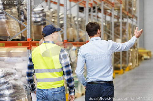 Image of businessman showing warehouse to worker