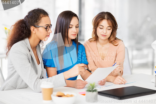 Image of businesswomen discussing papers at office