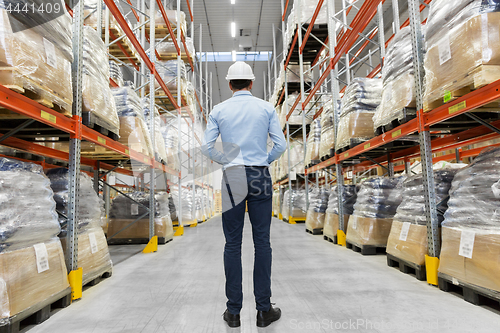 Image of businessman in helmet at warehouse