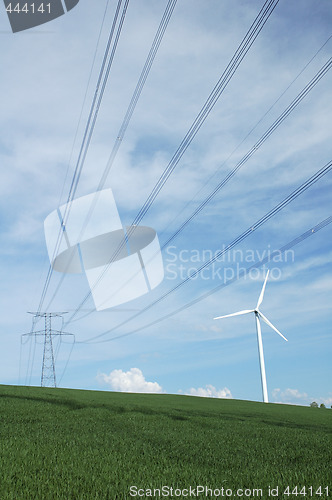 Image of a windturbine close to a electric pylon