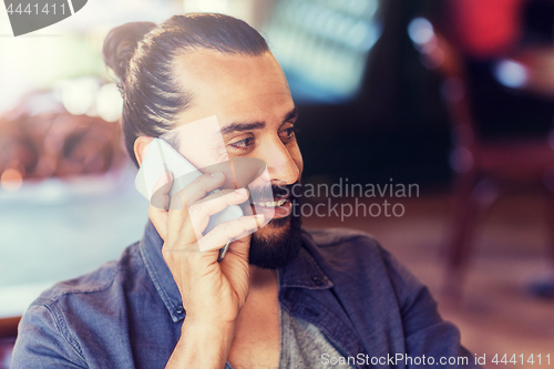 Image of happy man calling on smartphone at bar or pub