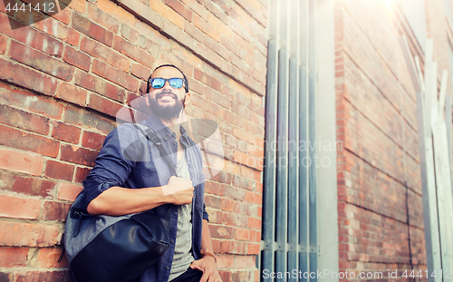 Image of happy man with backpack standing at city street