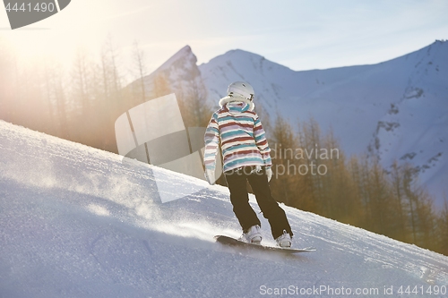 Image of Female snowboarder in sun flare