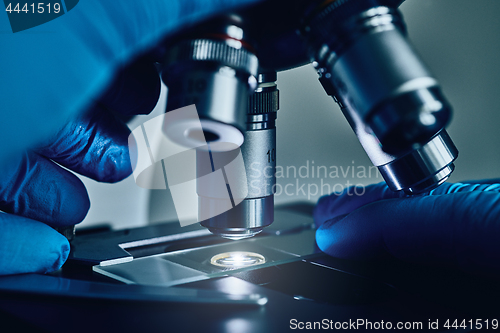 Image of Scientist hands with microscope