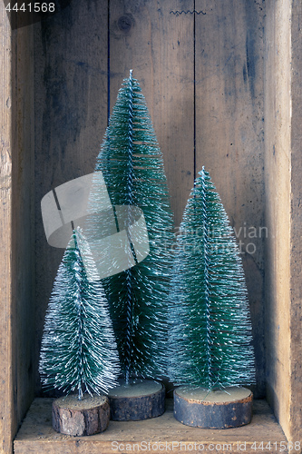Image of three Christmas tree objects in a wooden box