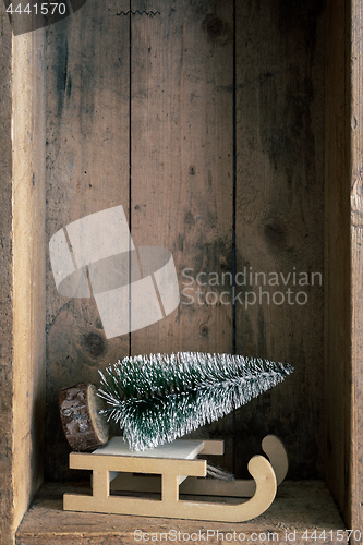 Image of Christmas decoration sledge and tree in a wooden box background