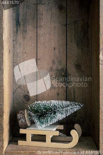Image of Christmas decoration sledge and tree in a wooden box background