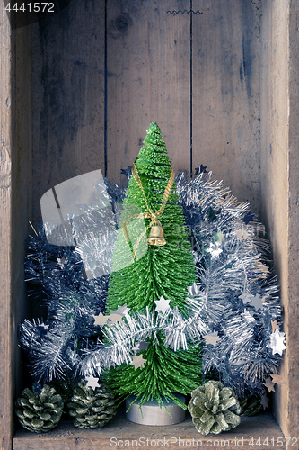 Image of Christmas decoration golden bell jar and tree in a wooden box ba