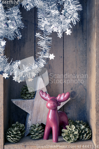 Image of Christmas decoration deer figure and star in a wooden box backgr