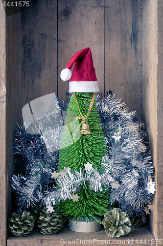 Image of Christmas decoration golden bell jar and tree in a wooden box ba