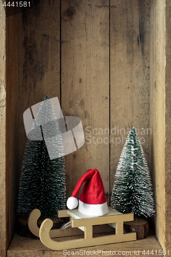 Image of Christmas decoration sledge with Santa Claus hat and trees in a 