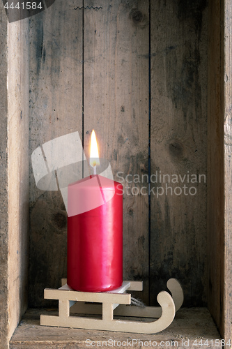 Image of Christmas decoration red candle on a sledge in a wooden box back