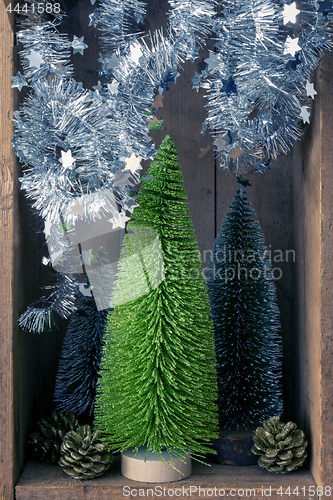 Image of Christmas decoration trees and pinecones in a wooden box backgro