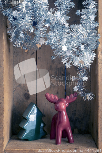 Image of Christmas decoration deer and tree figure in a wooden box backgr