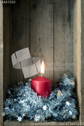 Image of Christmas decoration red candle in a wooden box background