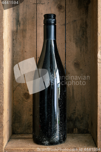 Image of a dirty bottle of wine in a wooden box