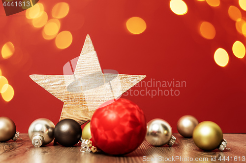 Image of Christmas decoration glass balls with wooden star and bokeh ligh