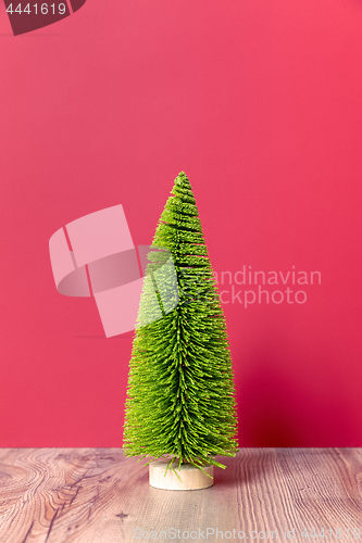 Image of Christmas decoration green fir tree figure on pink backgound