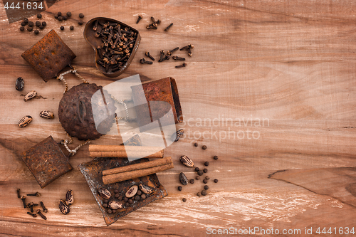 Image of Spices in rusty metal plates on wooden background