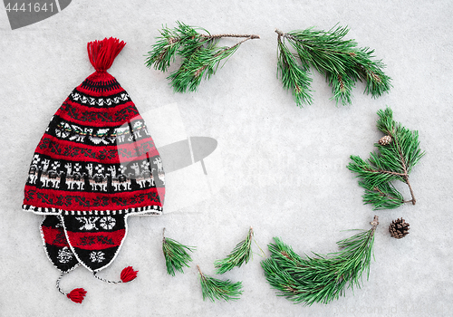 Image of Red winter hat and green pine branches