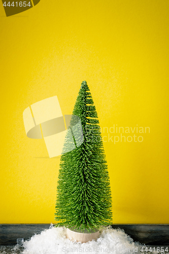 Image of Christmas decoration a fir trees in front of a yellow background