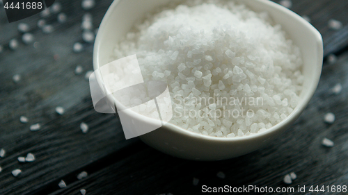 Image of Bowl of salt on dark desk 