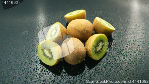 Image of Whole and cut kiwifruit on table 