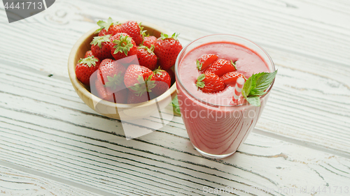 Image of Glass with smoothie and bowl of strawberries