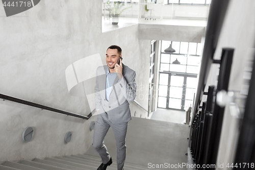 Image of businessman calling on smartphone at office