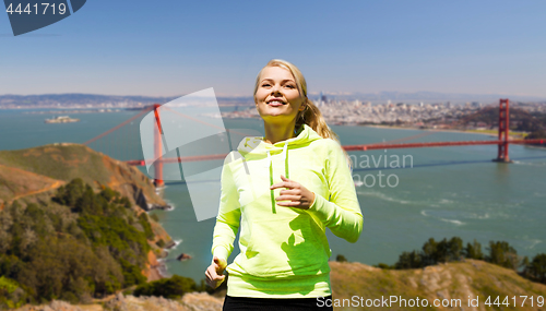 Image of smiling woman running over golden gate bringe