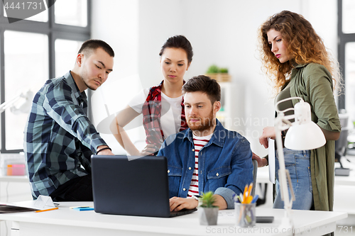 Image of creative team with laptop working at office