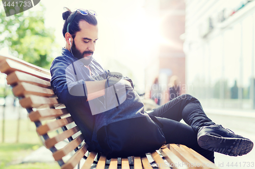 Image of man with backpack and earphones in city