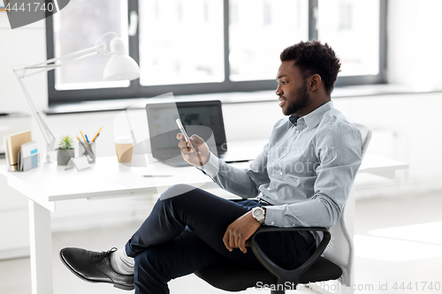 Image of businessman with smartphone at office