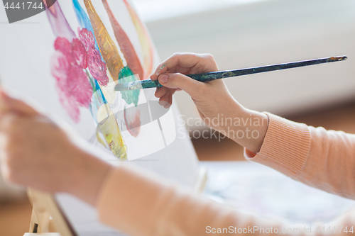 Image of artist with brush painting still life at studio