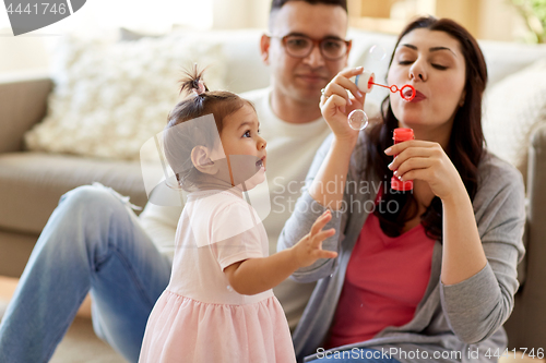 Image of family with soap bubbles playing at home