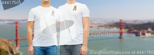 Image of close up of couple with gay pride rainbow ribbons