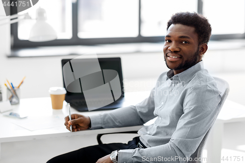 Image of african american businessman with pen at office