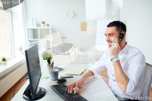 Image of businessman with headset and computer at office