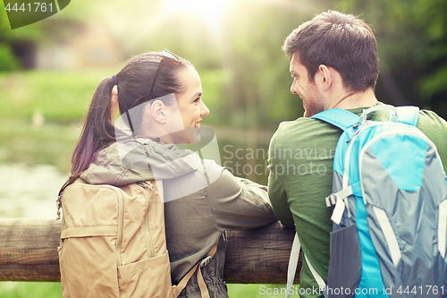 Image of smiling couple with backpacks in nature